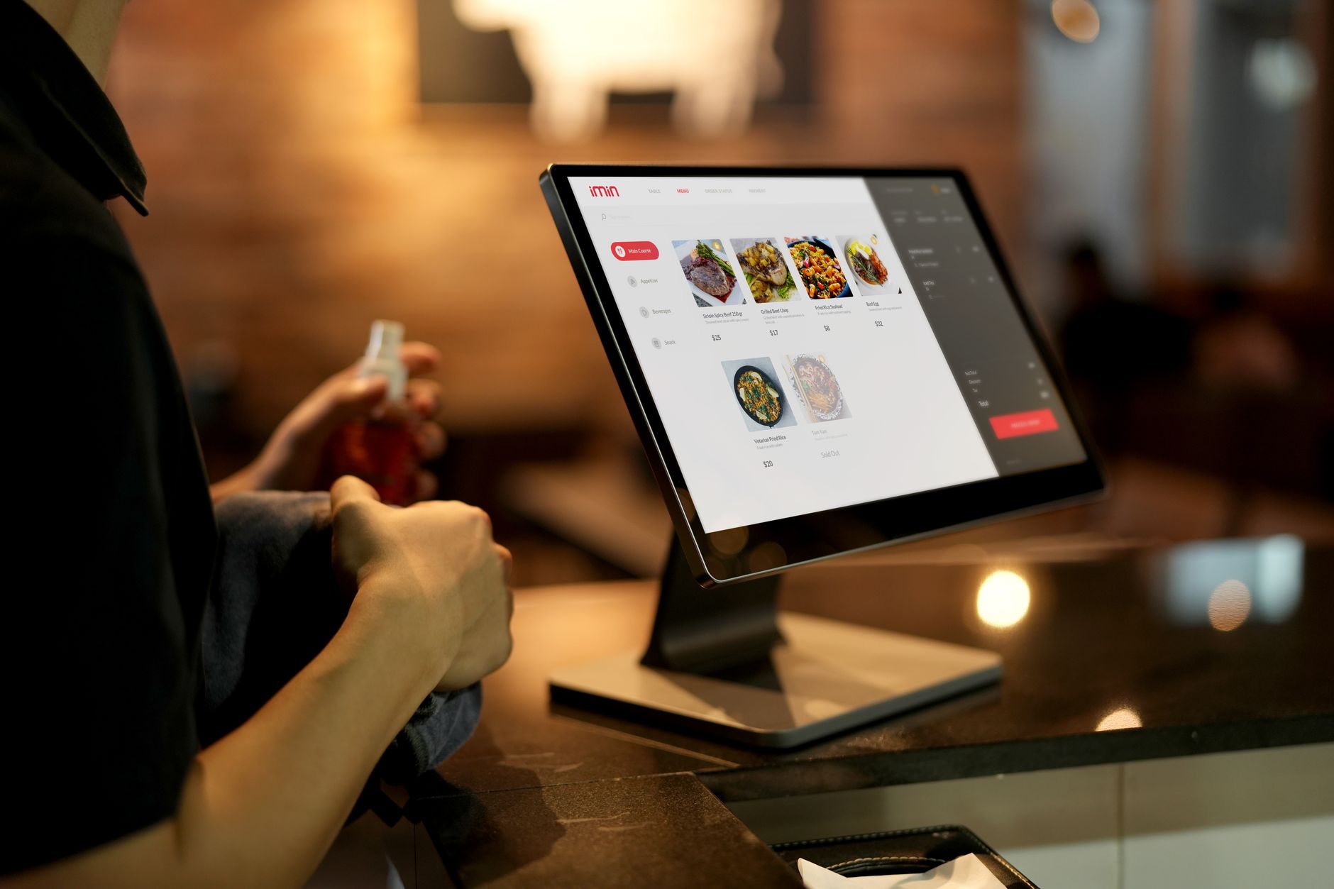 Customer using a digital tablet ordering system at a pub table, illustrating pub automation UK trends
